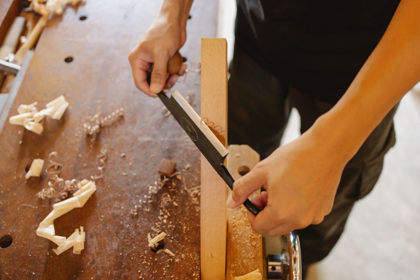 Manos trabajando madera en un taller